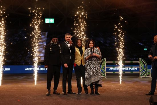 Op de foto staan wethouder Sport Mbarki met de blije winnaars Harvey Esajas en Diana Speksnijder op het podium. Tussen hen in staat een jonge jongen die bij I - Sport Special sport. Rechts staat half in beeld lachend presentator van de avond Umberto Tan.